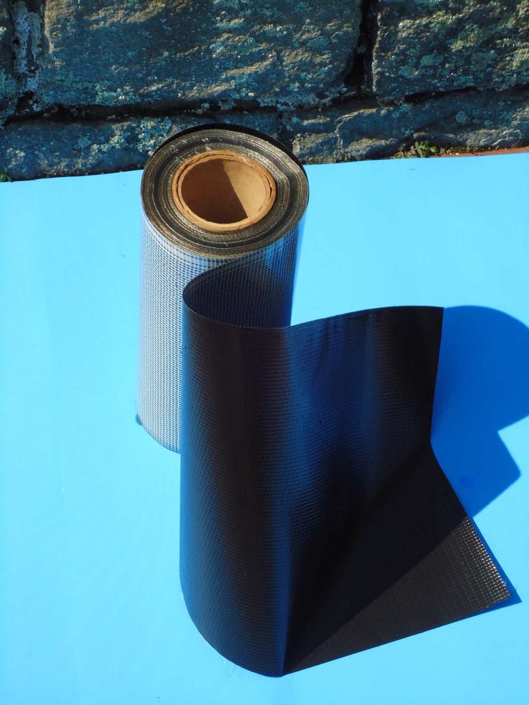 A roll of black paper next to a blue surface.