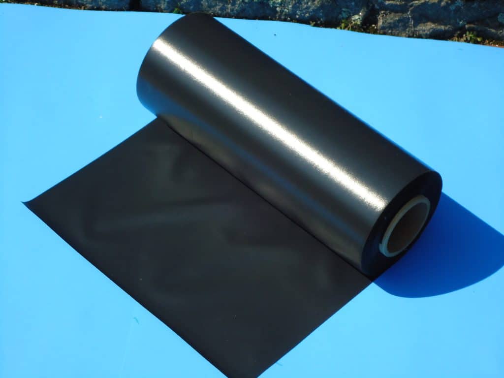 A roll of black plastic on top of a blue table.